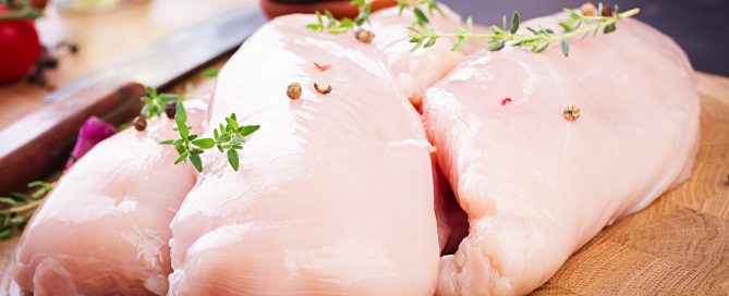 raw chicken breast fillets wooden cutting board with herbs spices